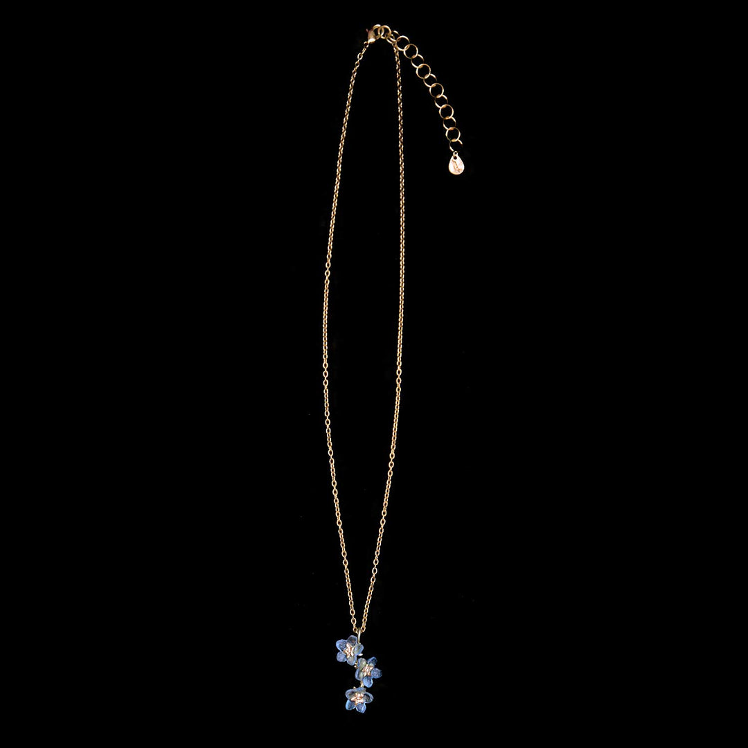 Necklace with a blue flower pendant on a black background