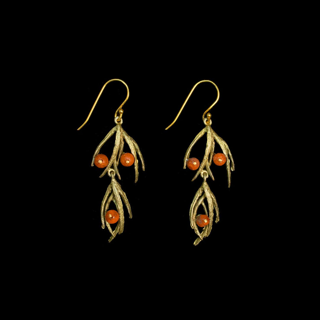 A pair of green-toned dangle earrings with leaf-like branches and three small round orange beads on each earring, shown against a solid black background.