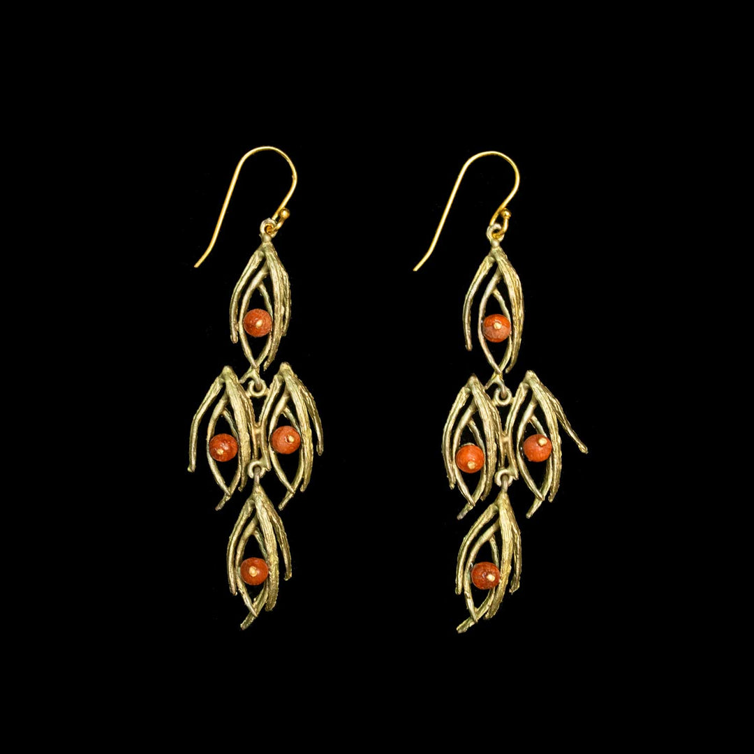 A pair of green-toned dangle earrings with leaf-like textured metalwork and three small round orange-red beads on each earring, shown against a solid black background.