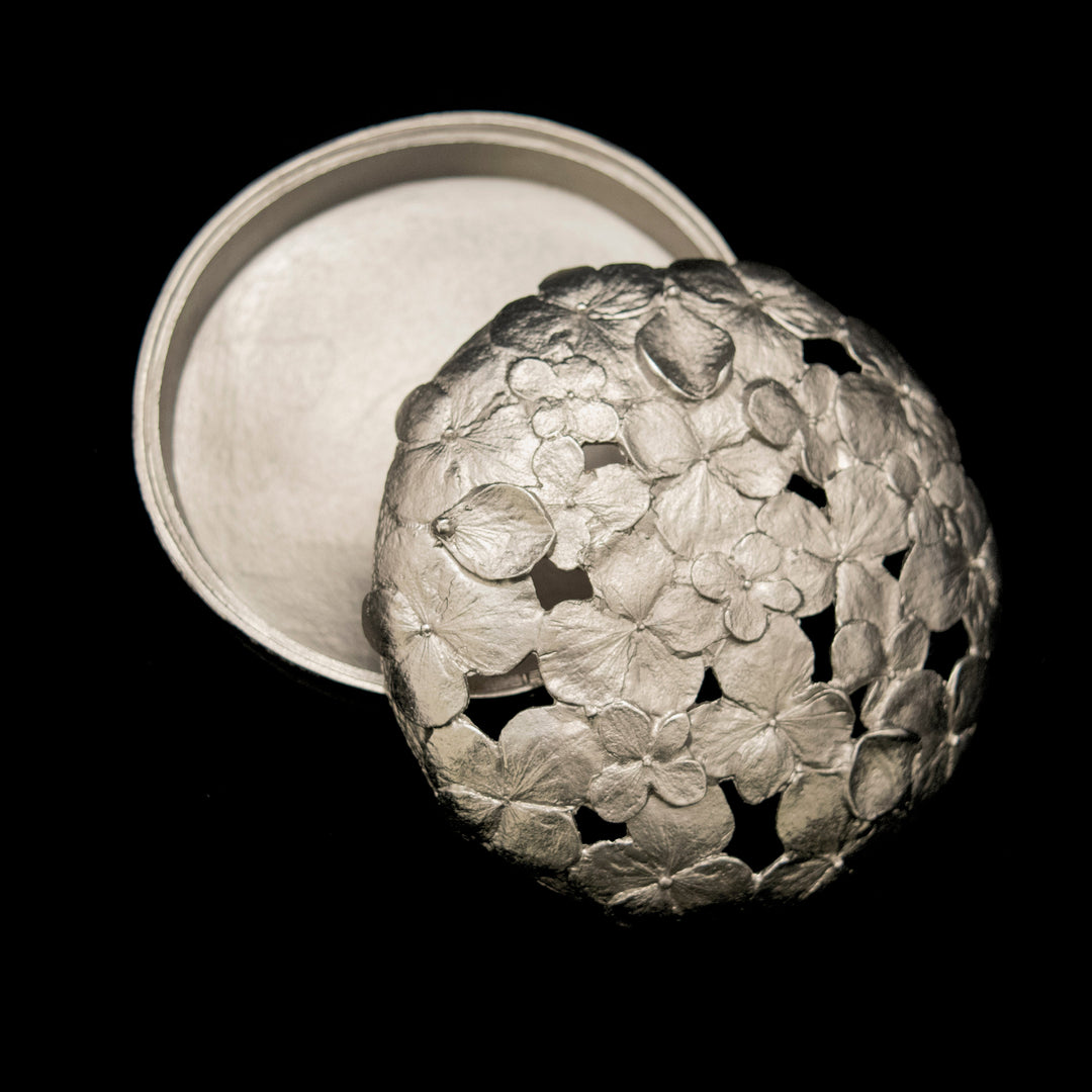 Decorative metal box with floral patterns on a black background