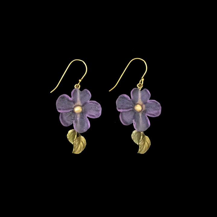 A pair of handcrafted earrings featuring purple flower-shaped pendants with green-colored leaves and hooks, set against a black background—perfect nature-inspired accessories.