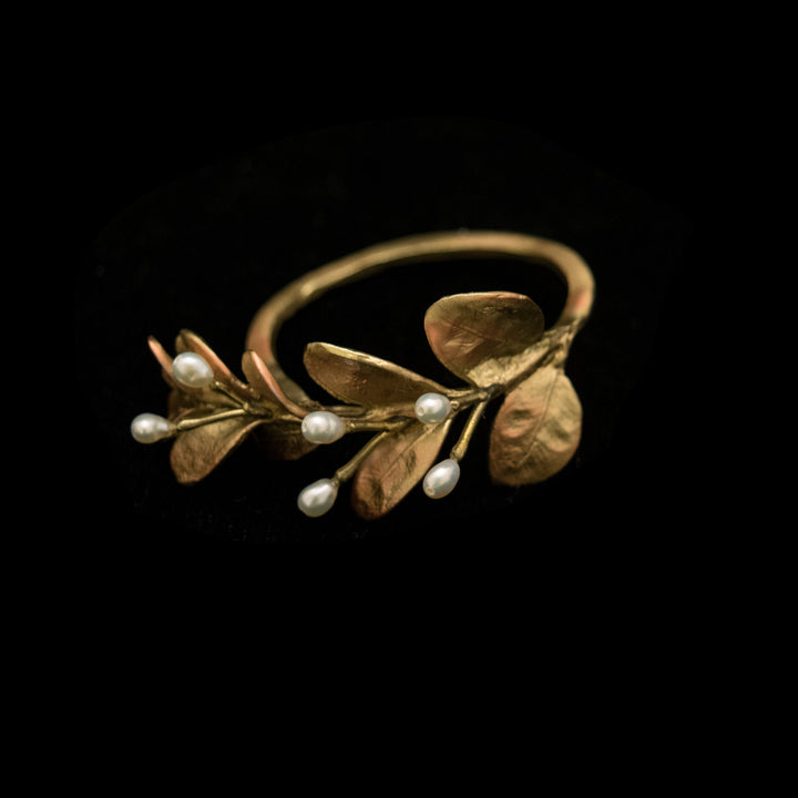 golden leaf-shaped napkin ring with pearls on a black background