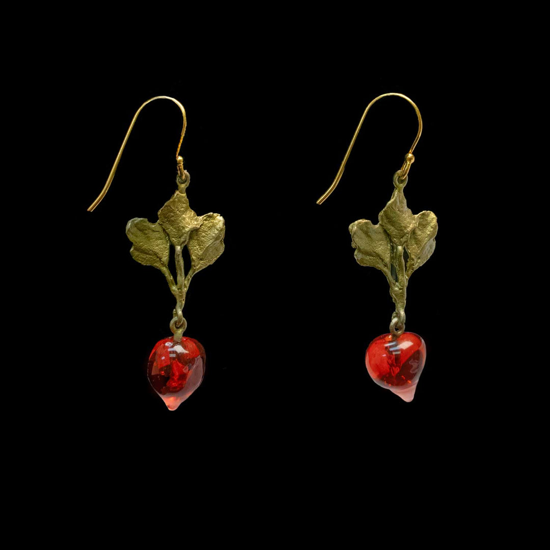 A pair of dangling earrings with textured green-tone leaf charms and red heart-shaped glass drops, shown against a solid black background.