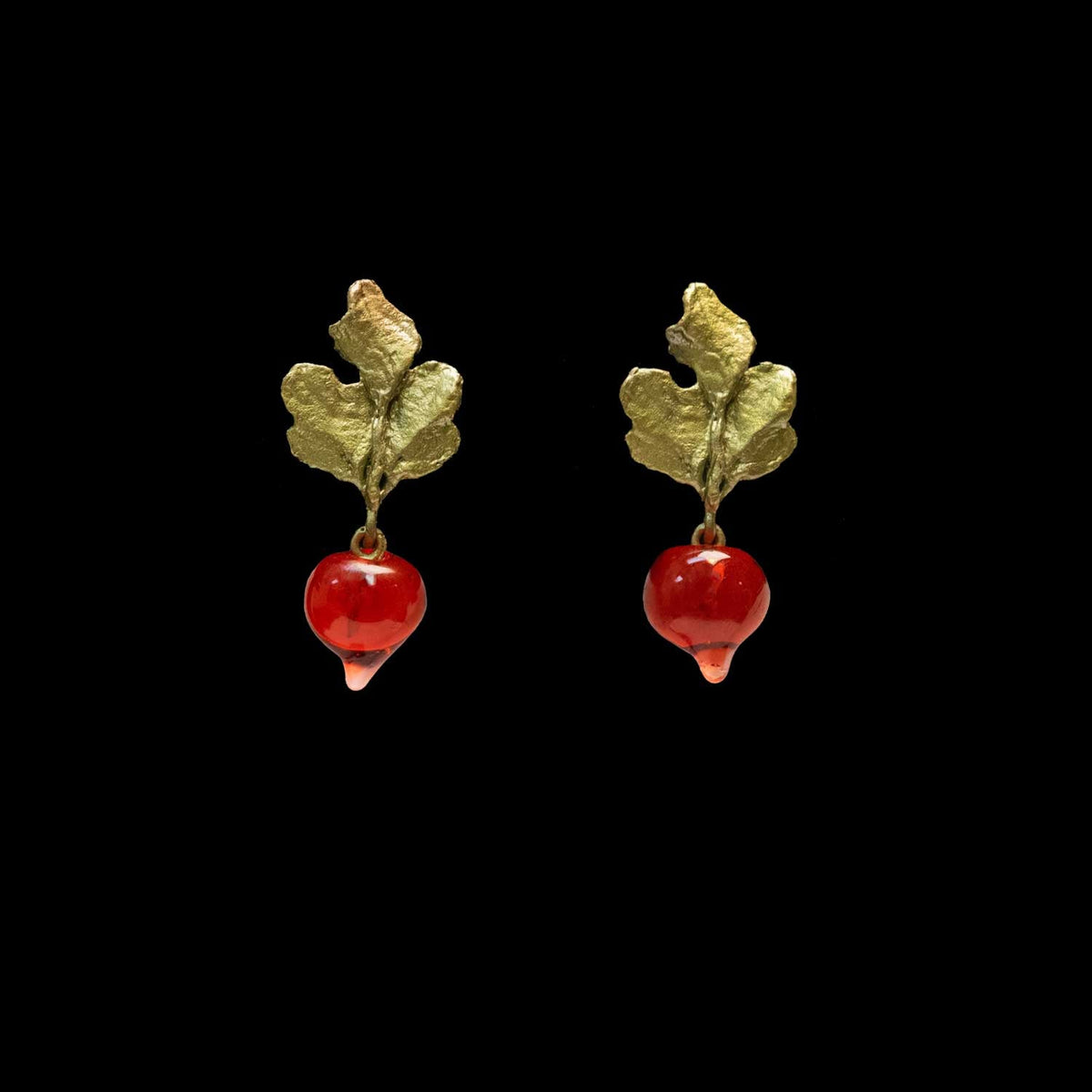 A pair of green leaf and radish-shaped earrings with glossy red glass radish, shown against a solid black background.