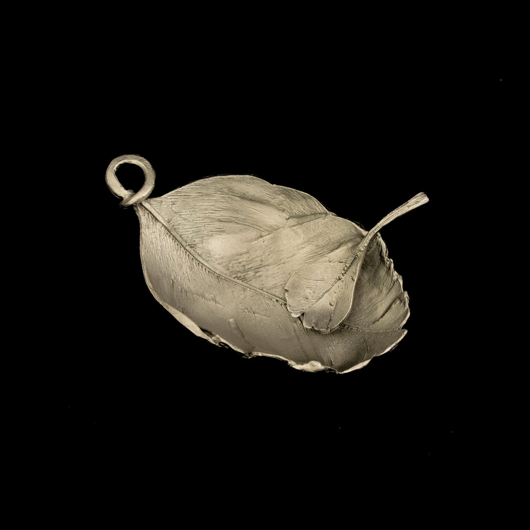 Silver leaf-shaped pendant on a black background