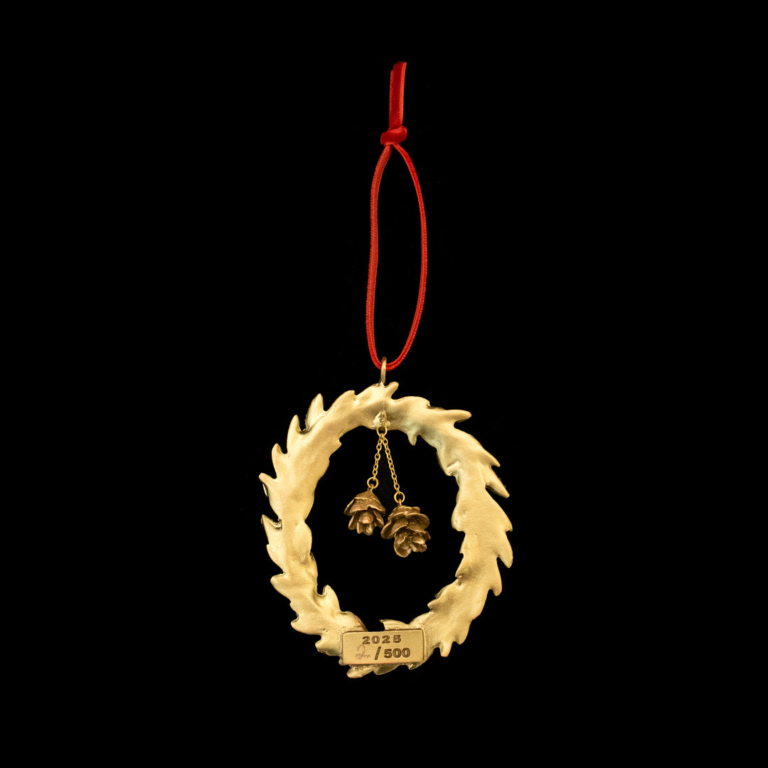 Decorative wreath ornament with pine cones on a black background