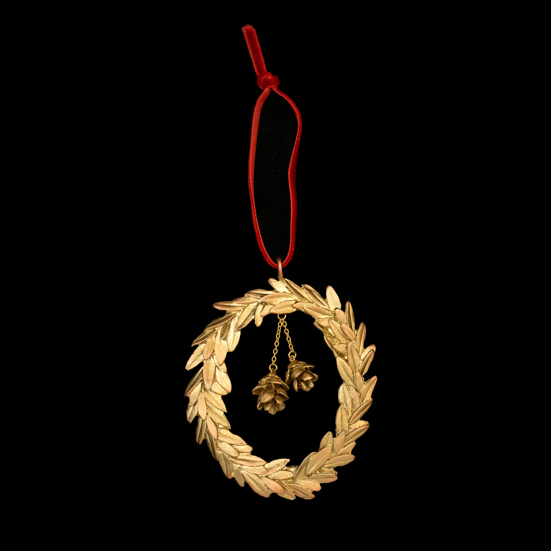 Golden wreath ornament with pine cones on a black background
